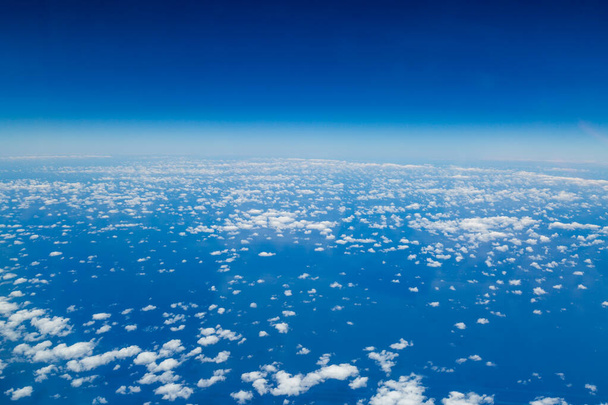 A view of clouds and the curvature of the earth, taken from the flightdeck of an airplane - Foto, Imagen