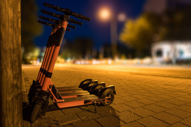 E-skutery do transportu w środowisku miejskim, miasto nocą - Zdjęcie, obraz
