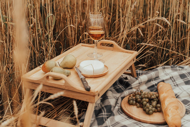 Verão recreação ao ar livre. Piquenique no campo de trigo. Aperol, pêssegos, uvas e queijo - Foto, Imagem