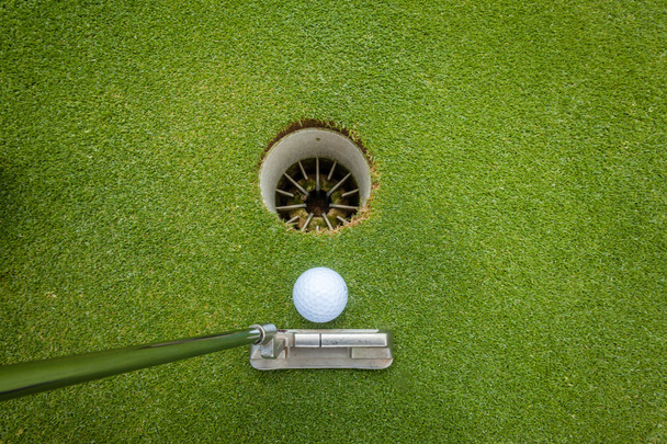 Golf putter golyó lyukba - Fotó, kép