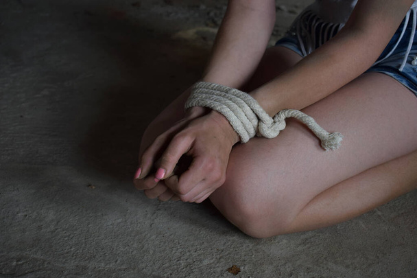 Manos femeninas atadas con cuerda, aterrorizadas, rehenes, asustadas. Detener la violencia contra la mujer, el abuso sexual, la violencia doméstica y la trata. Día de los Derechos Humanos. - Foto, Imagen