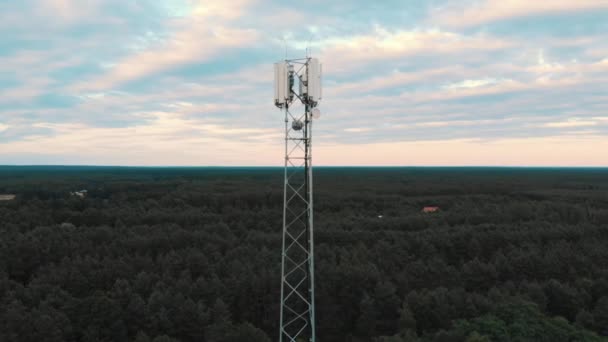 luchtfoto van de 5G antenne die boven de weg uitsteekt en velden met bomen. Landelijk. Parallaxschot - Video