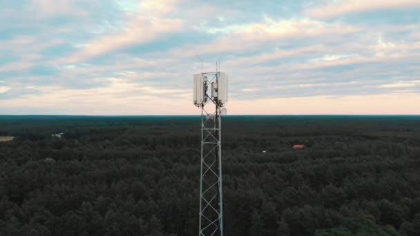 Torre con antenas de 5g que se elevan sobre el bosque. Concepto de telecomunicaciones. Disparo descendente - Metraje, vídeo