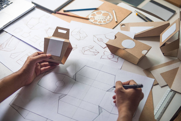 Designer sketching drawing design Brown craft cardboard paper product eco packaging mockup box development template package branding Label . designer studio concept . - 写真・画像