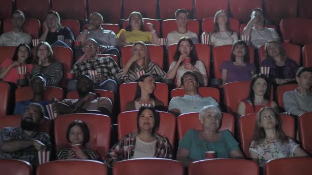 Мультиэтнические зрители смотрят кино в кино - Кадры, видео