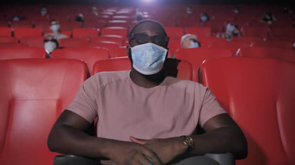 Porträt eines maskierten afrikanisch-amerikanischen Mannes im Kino - Filmmaterial, Video
