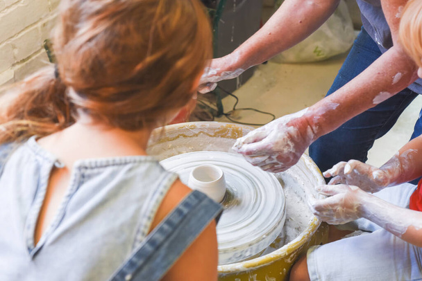 Crianças aprendendo a fazer cerâmica como um hobby com sua avó em uma oficina de cerâmica
 - Foto, Imagem