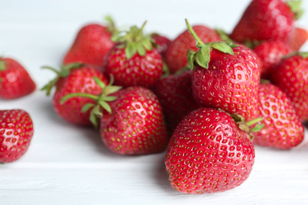 Delicious ripe strawberries on white wooden table, closeup - Valokuva, kuva