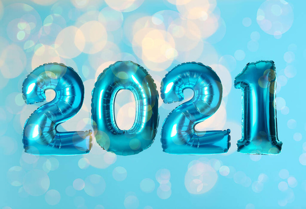 2021 New Year celebration. Bright balloons and blurred lights on light blue background - Foto, afbeelding