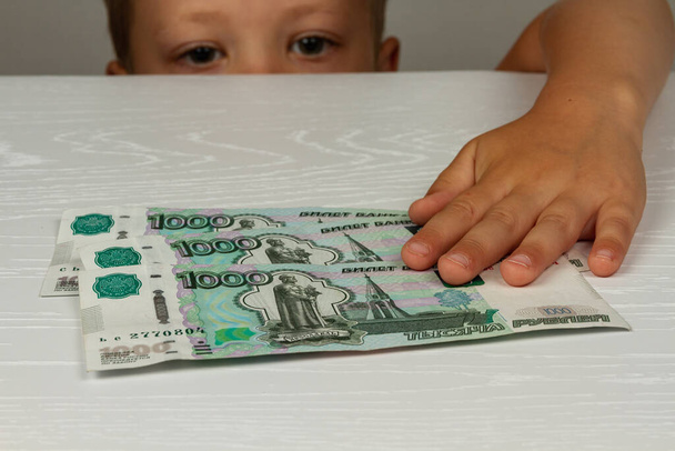το παιδί έλαβε χρήματα από το κράτος κατά τη διάρκεια της περιόδου coronavirus - Φωτογραφία, εικόνα