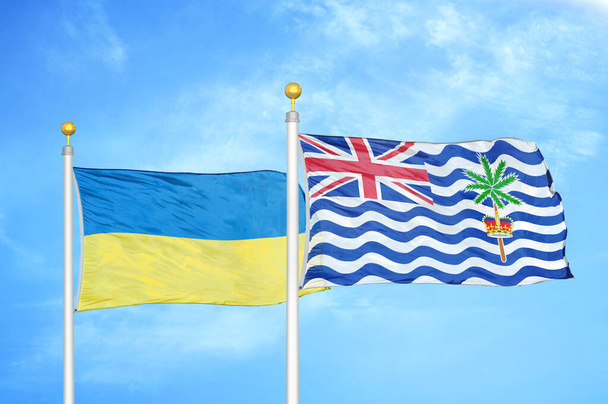 Ucraina e Territorio Indiano Britannico due bandiere su pennoni e cielo blu nuvoloso sfondo - Foto, immagini