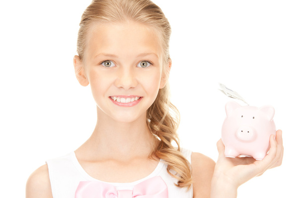 Lovely teenage girl with piggy bank and money - 写真・画像