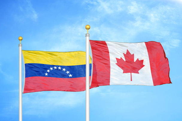 Venezuela et Canada deux drapeaux sur mâts et ciel bleu nuageux - Photo, image