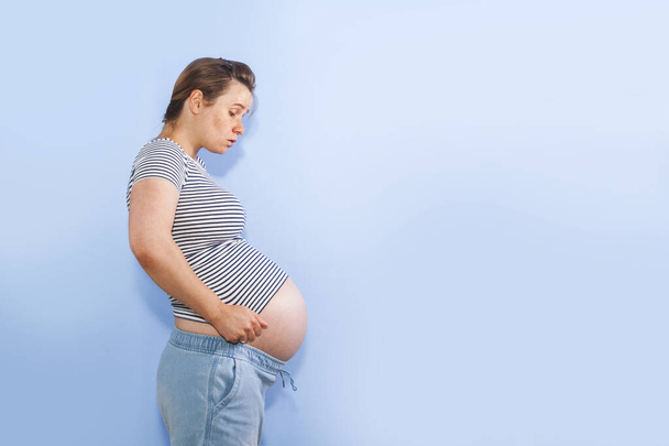 Donna incinta su uno sfondo blu parete
 - Foto, immagini
