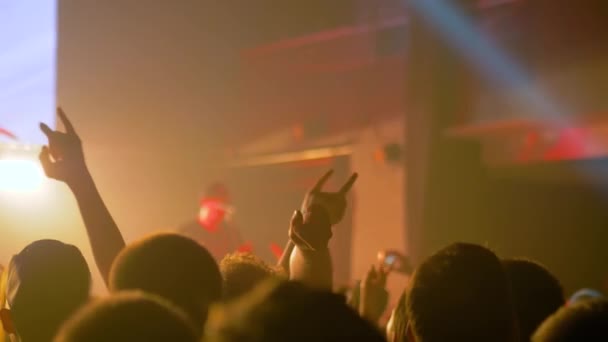 Cámara lenta: siluetas de gente festejando en un concierto de rock frente al escenario - Metraje, vídeo