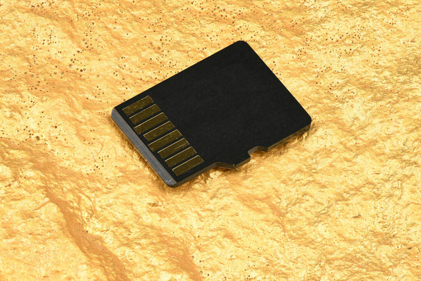Cartão de memória SD isolado em fundo dourado. Foto de alta resolução. Profundidade total do campo
. - Foto, Imagem