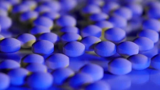 Blauwe pillen verspreid over een glazen tafel - Video