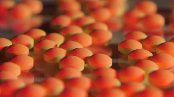 Pilules rouges éparpillées sur une table en verre - Séquence, vidéo