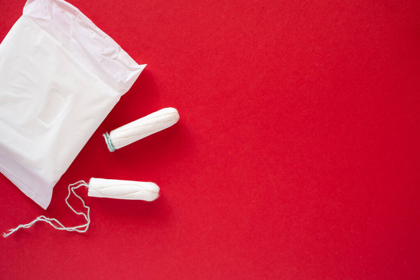 Sanitary pad and tampons on red isolated background - 写真・画像