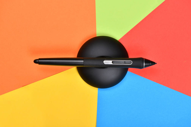 Ψηφιακή γραφιστική πένα σε πολύχρωμο φόντο. Φωτογραφία υψηλής ανάλυσης. Πλήρες βάθος πεδίου. - Φωτογραφία, εικόνα