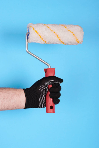 Hand in working glove with paint roller. - Photo, image
