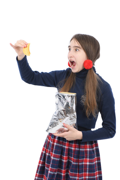 Porträt eines vorpubertierenden Mädchens mit Kartoffelchips. Vereinzelt auf weißem Hintergrund. Foto in hoher Auflösung. Volle Schärfentiefe. - Foto, Bild