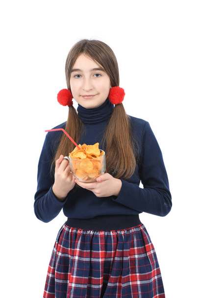 Vorpubertierendes Mädchen hält eine Schüssel voller Kartoffelchips in der Hand. Vereinzelt auf weißem Hintergrund. Foto in hoher Auflösung. Volle Schärfentiefe. - Foto, Bild