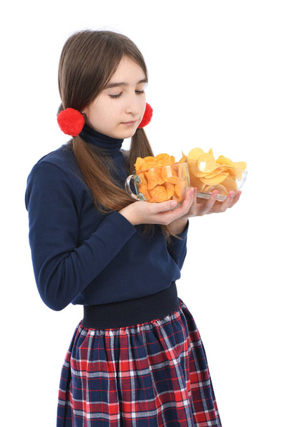 La chica preadolescente sosteniendo un tazón está llena de papas fritas. Aislado sobre fondo blanco. Foto de alta resolución. Profundidad total del campo. - Foto, imagen
