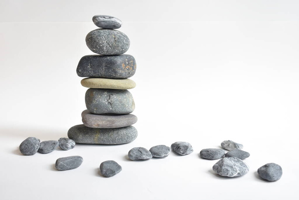 Stack stones isolated in white background. Pebbles tower. Concept of balance and harmony. Calm and spirit, spa stones and zen, peace, meditation, spiritual, abstract - Photo, Image