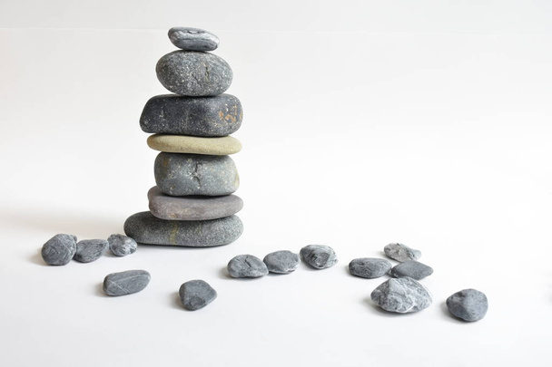 Piedras apiladas aisladas en fondo blanco. Torre de guijarros. Concepto de equilibrio y armonía. Calma y espíritu, piedras de spa y zen, paz, meditación, espiritual, abstracto - Foto, imagen