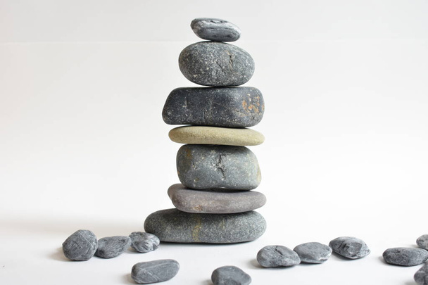 Kamienie stos izolowane w białym tle. Kamienna wieża. Koncepcja równowagi i harmonii. Spokój i duch, kamienie uzdrowiskowe i zen, spokój, medytacja, duchowe, abstrakcyjne - Zdjęcie, obraz