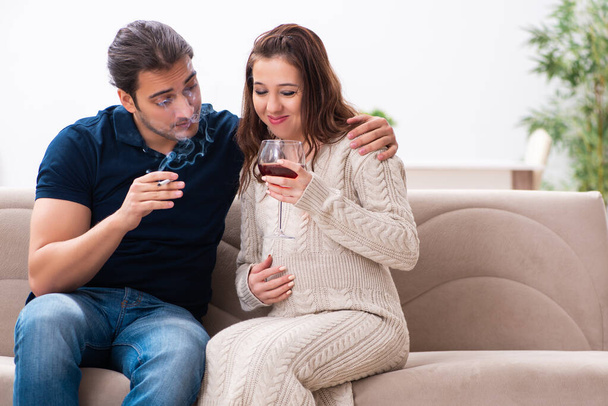 Hombre y mujer embarazada en concepto de hábitos nocivos - Foto, imagen