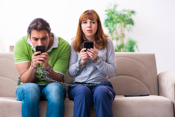 Young couple in gadget dependency concept - Photo, Image