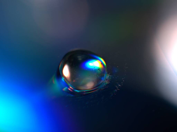 Koyu mavi arkaplanda su damlacıkları ve parlak damlalar, bulanık ve makro görüntü  - Fotoğraf, Görsel
