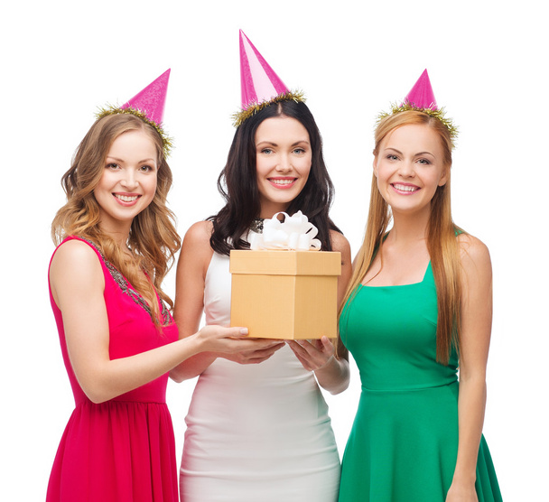 Three smiling women in blue hats with gift box - Valokuva, kuva