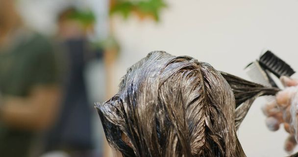Woman dye her hair at beauty salon - Foto, imagen