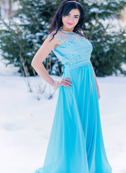 Christmas or New Year Holidays, magical atmosphere and pretty woman in long dress at snowy day. Inspiration and winter idea - Photo, Image