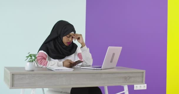 Nuori musliminainen työskentelee tietokoneella  - Materiaali, video