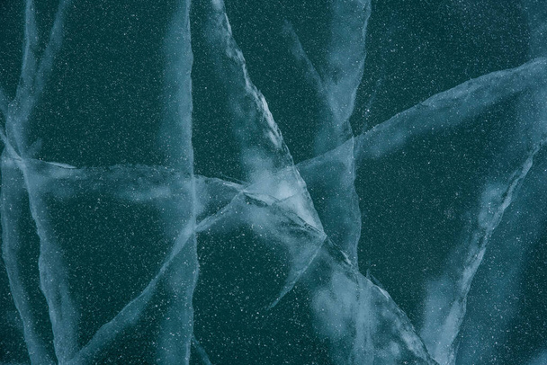 Ice texture close-up. Frozen Baikal lake in Siberia. Beautiful cracked ice with air and methane bubbles.  - Photo, image