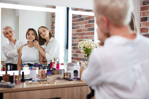 make-up artist and hair stylist work together in beauty salon - Foto, Imagem