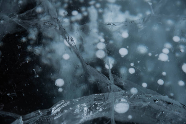 Структура льда крупным планом. Замерзшее Байкальское озеро в Сибири. Прекрасный треснувший лед с пузырьками воздуха и метана.  - Фото, изображение