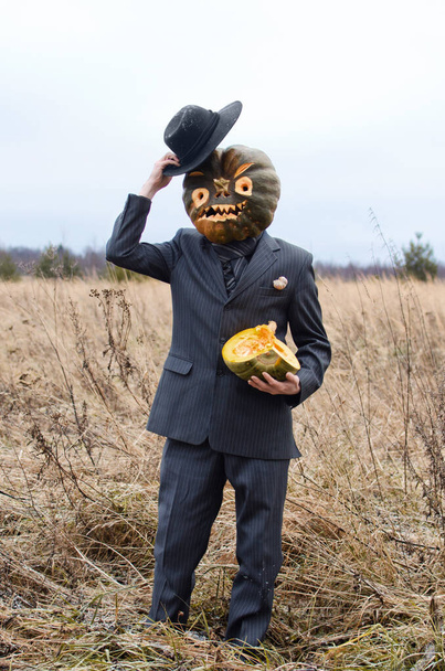 man in a fancy dress celebrates Halloween in an autumn field among dry grasses - Photo, Image