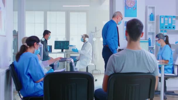 Médecin avec visière et patient en salle d'examen - Séquence, vidéo