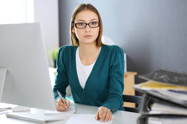 Accountant checking financial statement or counting by calculator income for tax form, hands close-up. Business woman sitting and working at the desk in office. Audit concept - Photo, Image