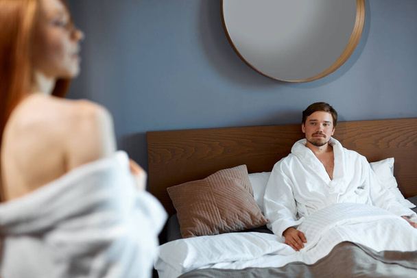 adorable woman is flirting with man in hotel room - Valokuva, kuva