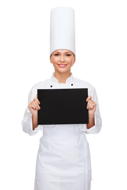 Smiling female chef with black blank paper - Φωτογραφία, εικόνα