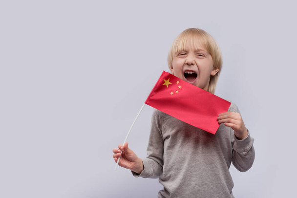 A gyerek Kína zászlaját viseli. Kínaiul tanulási nehézség. - Fotó, kép