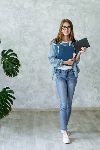 Smiling caucasian girl in glasses holding books - Valokuva, kuva