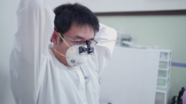 Asiatischer Arzt macht sich bereit für den Operationskoffer, Arbeitsschutz, persönliche Schutzausrüstung weißer medizinischer Anzug, N95-Maske, Covid-19-Infektionsvirus, Coronaprävention, desinfizierte Einrichtungen - Filmmaterial, Video