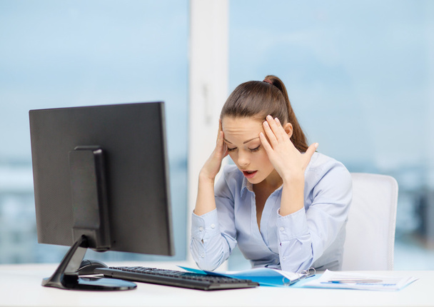 Stressed woman with computer and documents - Foto, afbeelding
